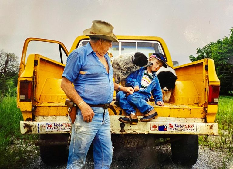 A grandfather and his grandson on the bed of their truck